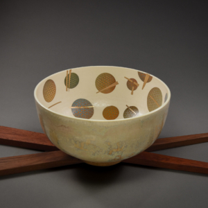 Chopsticks in Orbit Bowl. Porcelain, Glaze, Custom Ceramic Decals, Gold Enamel, Wood Base.  22 x 10 x 6 inches. &copy;Julia Mulligan